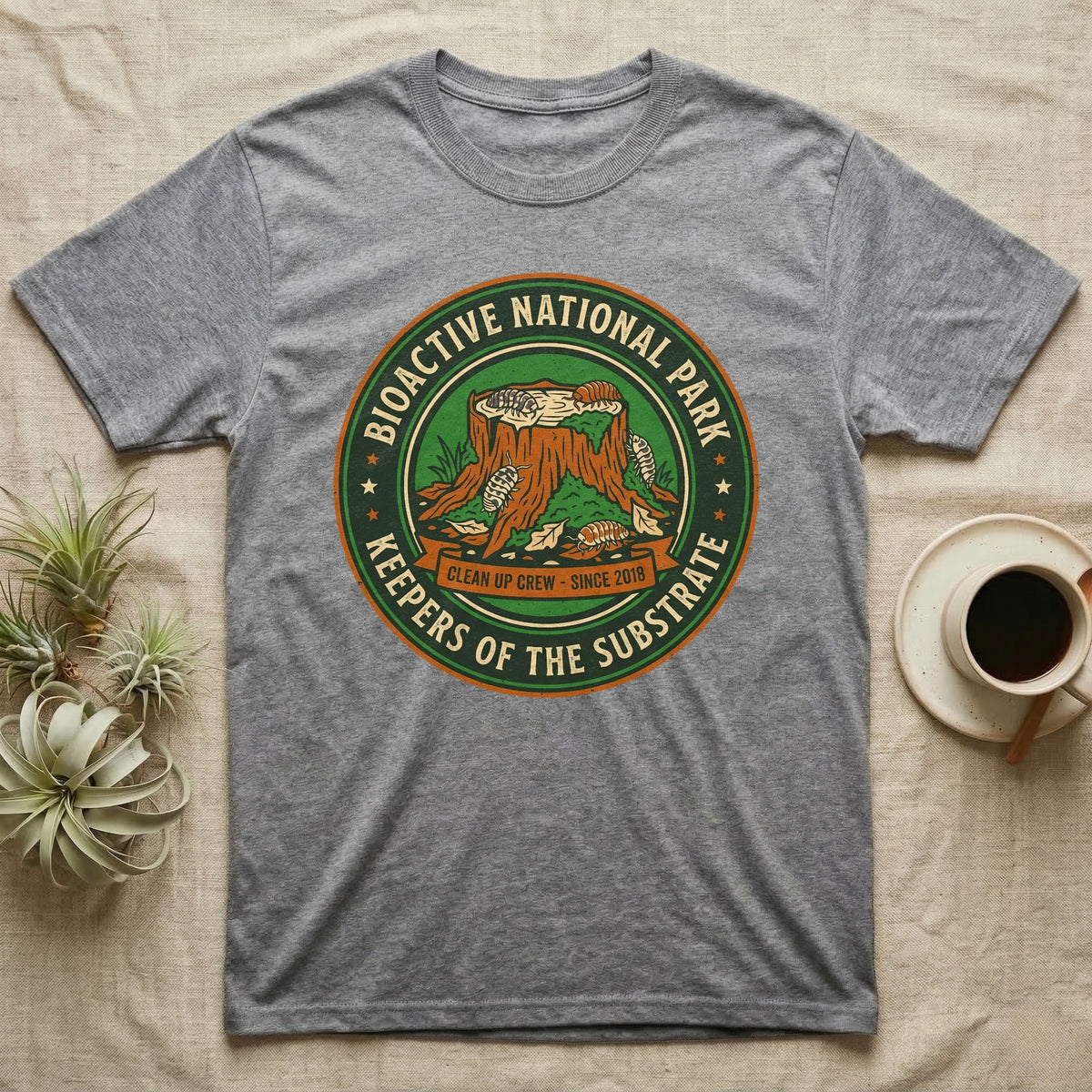 Isopod Keepers of the Substrate T-Shirt in Sport Grey — Weathered green park badge with isopods working a mossy stump and leaf litter, cream arc lettering.