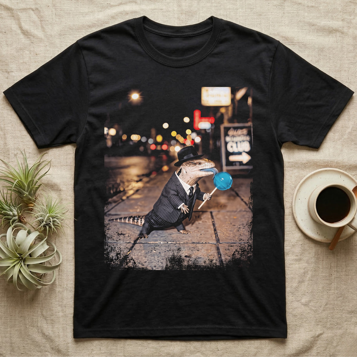 Blue Tongue Skink Detective T-Shirt in Black — Blue-tongued skink in a pinstripe suit and fedora holding a blue lollipop on a neon-lit rainy street.
