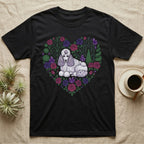 Black t-shirt with a white poodle in a heart-shaped floral arrangement.