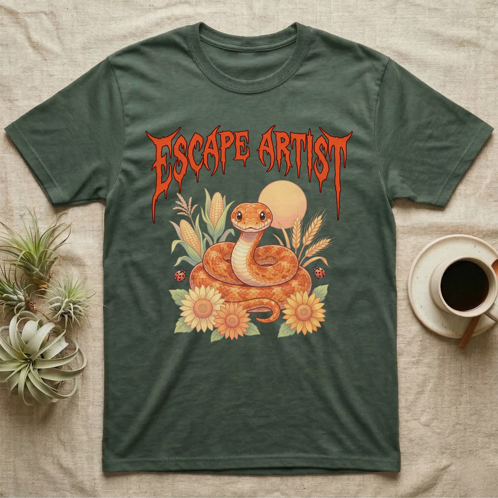 Corn Snake Feral T-Shirt in Military Green — Orange corn snake coiled in a pastel cornfield scene under a spiky blood-orange metal wordmark reading ESCAPE ARTIST.