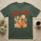 Corn Snake Feral T-Shirt in Military Green — Orange corn snake coiled in a pastel cornfield scene under a spiky blood-orange metal wordmark reading ESCAPE ARTIST.