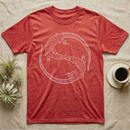 Ackie Monitor Roundel T-Shirt in Heather Red — Two ackie monitors in fine white line art, mirrored at 180 degrees around a tiny heart, tails sweeping outward.