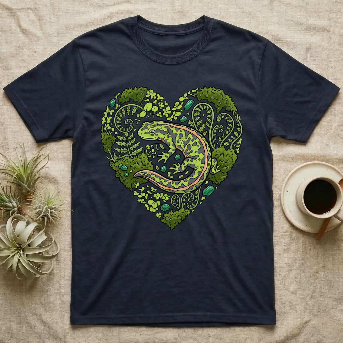 Dark t-shirt with a green salamander inside a heart-shaped floral design.