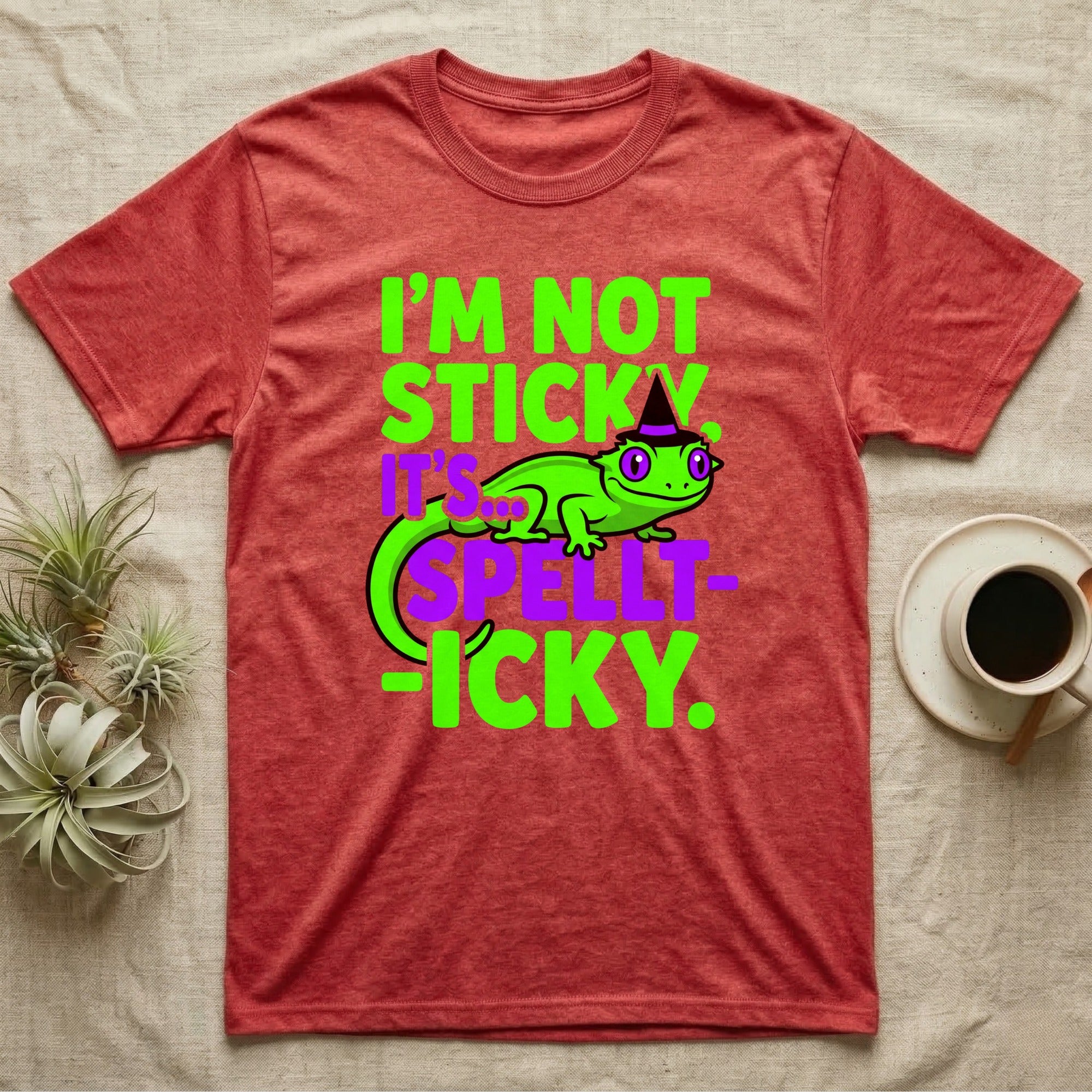 Crested Gecko Spellt-icky T-Shirt in Heather Red — Neon cartoon crested gecko in a witch hat with stacked text, "I'm Not Sticky, It's Spellt-icky."
