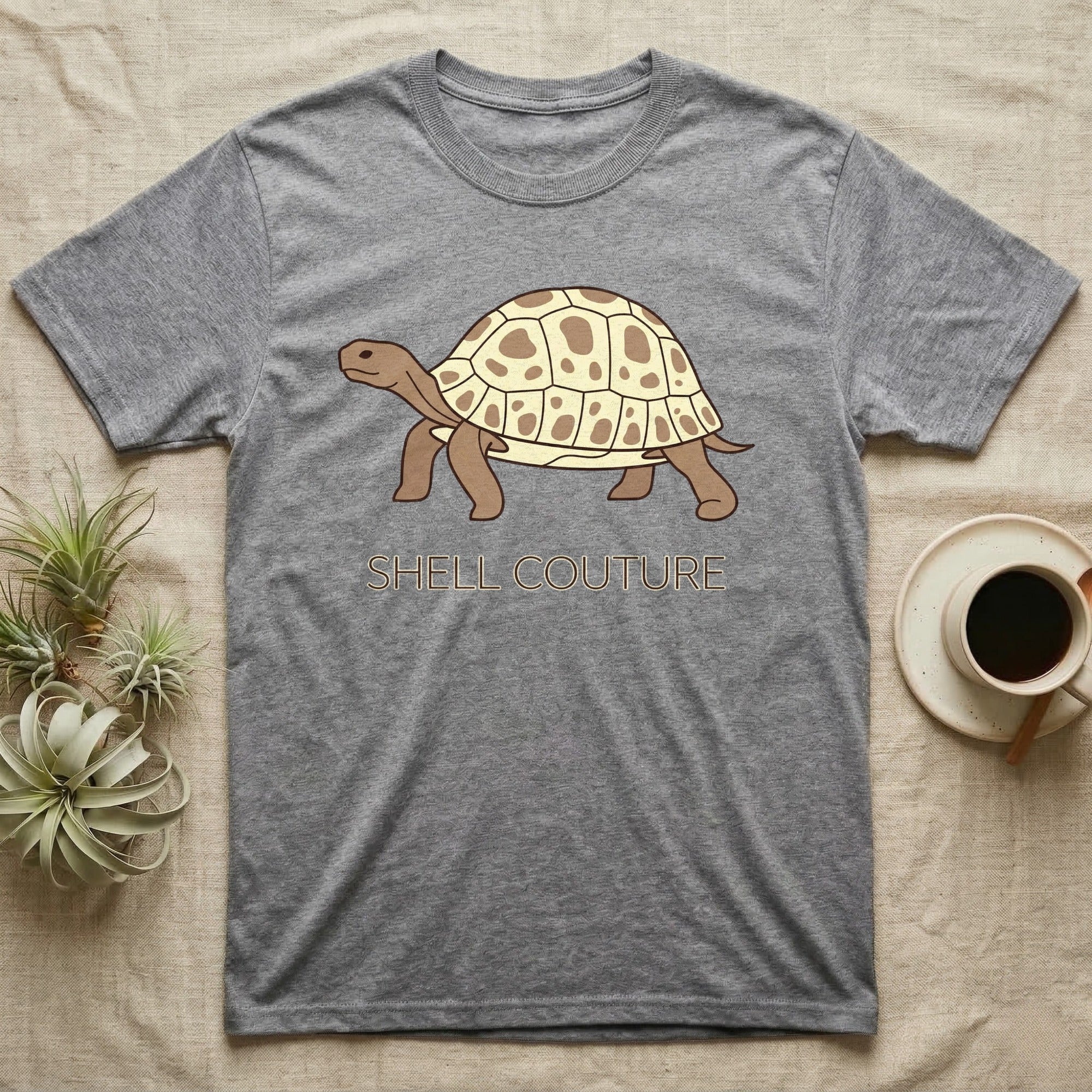 Grey t-shirt with a cartoon tortoise and "SHELL COUTURE" text.