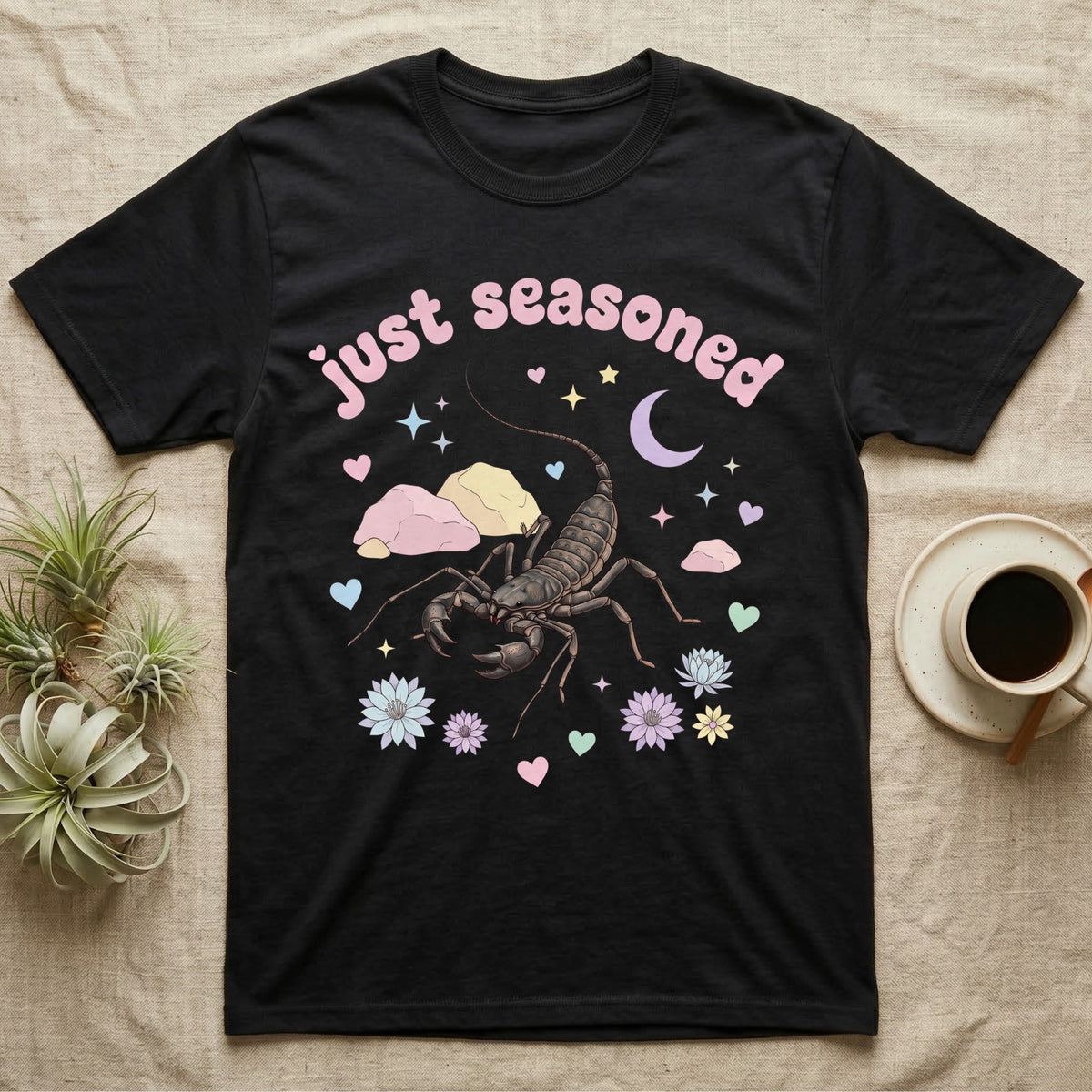 Giant Vinegaroon Baby T-Shirt in Black — Pastel giant vinegaroon with pincers and whip tail among rocks and a crescent moon, puffy pink wordmark "just seasoned" above.