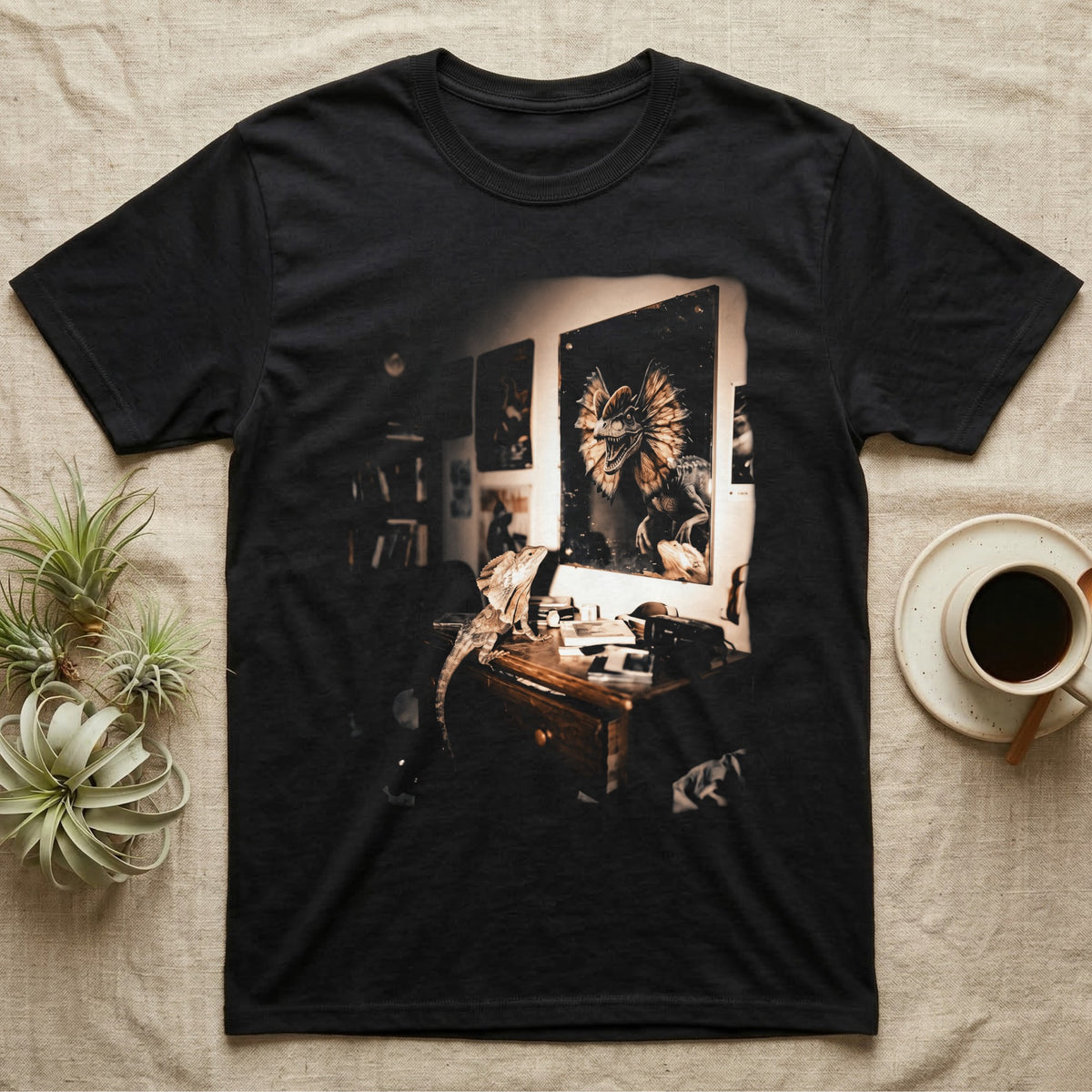 Frilled Lizard Dinosaur Mirror T-Shirt in Black — Frilled lizard on a desk looking at a wall mirror reflecting a large frilled dinosaur with its frill flared.
