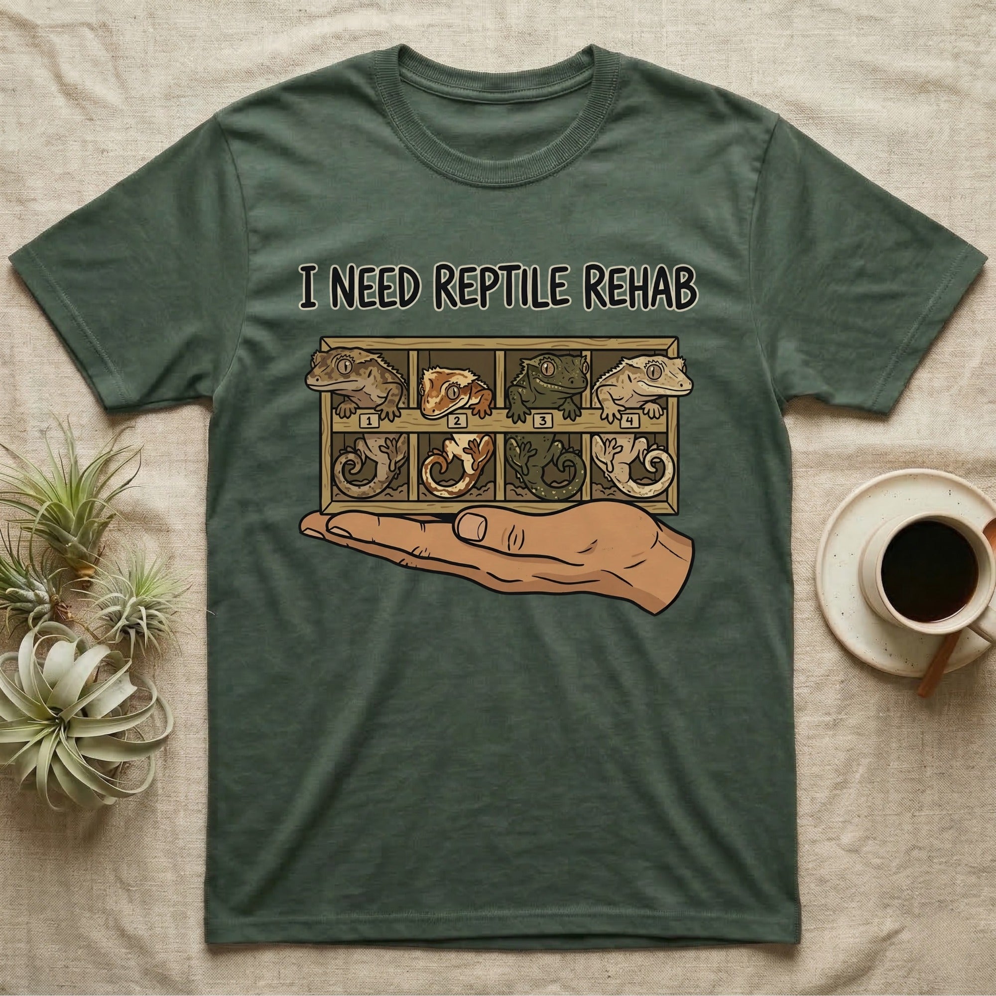 Crested Gecko Rehab T-Shirt in Military Green — Vector scene of a hand presenting a rack of four crested geckos under a marker-style reptile rehab caption.