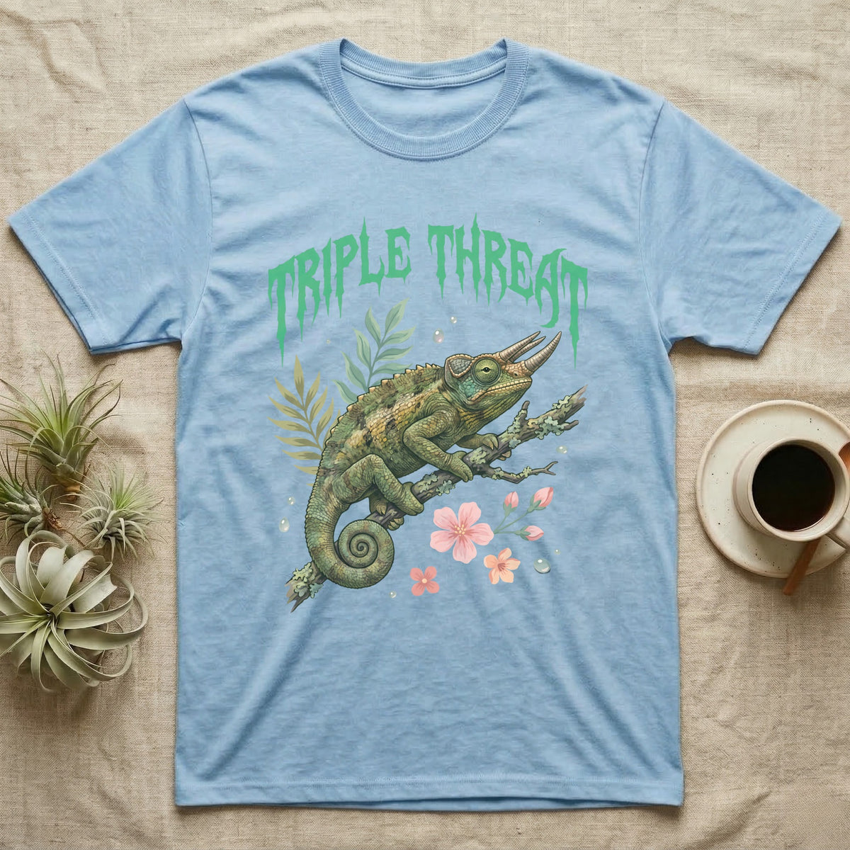 Jackson's Chameleon Feral T-Shirt in Light Blue — Three-horned Jackson's chameleon on a branch below a dripping jade-green metal "Triple Threat" wordmark