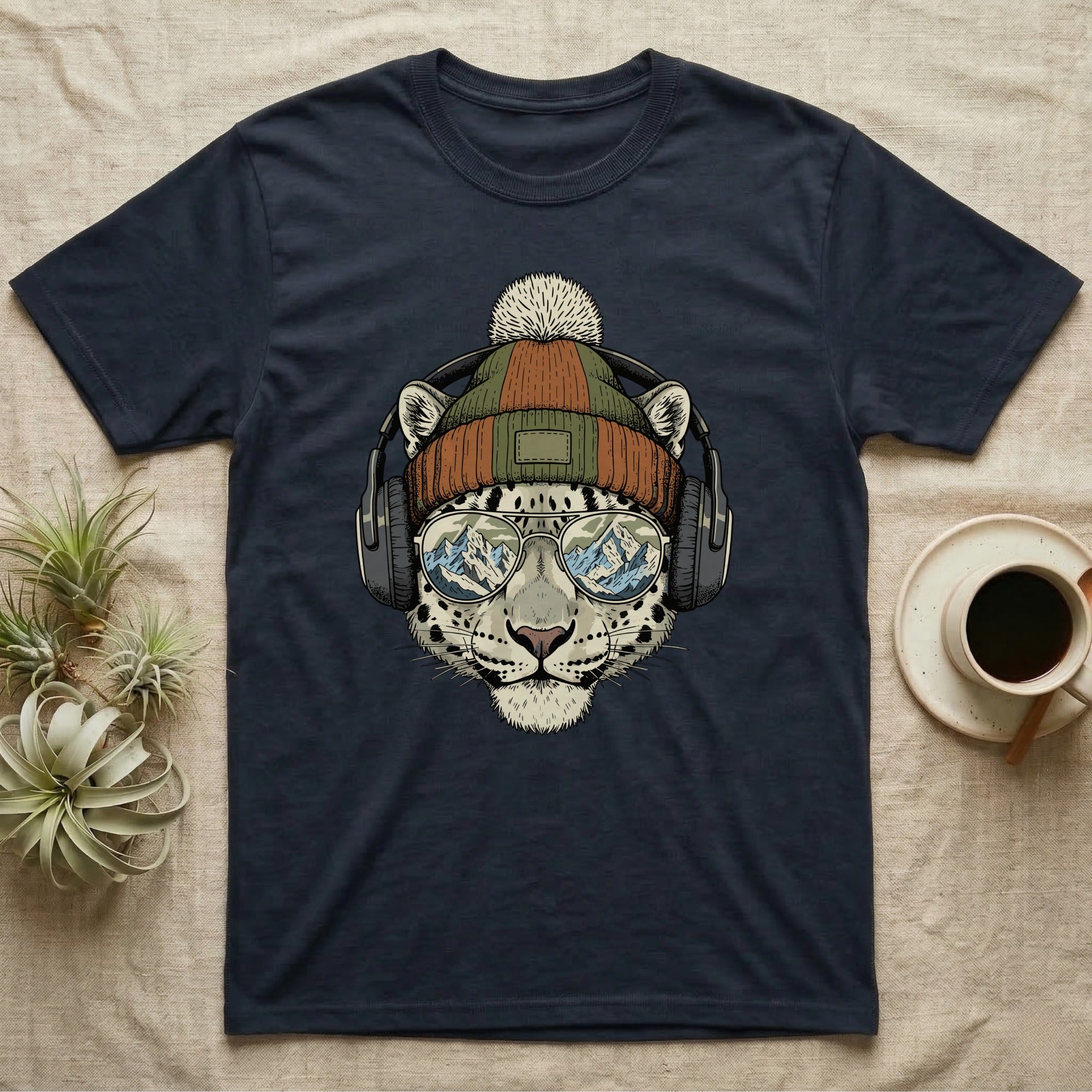 Navy t-shirt featuring a snow leopard wearing headphones and sunglasses reflecting a mountain scene.