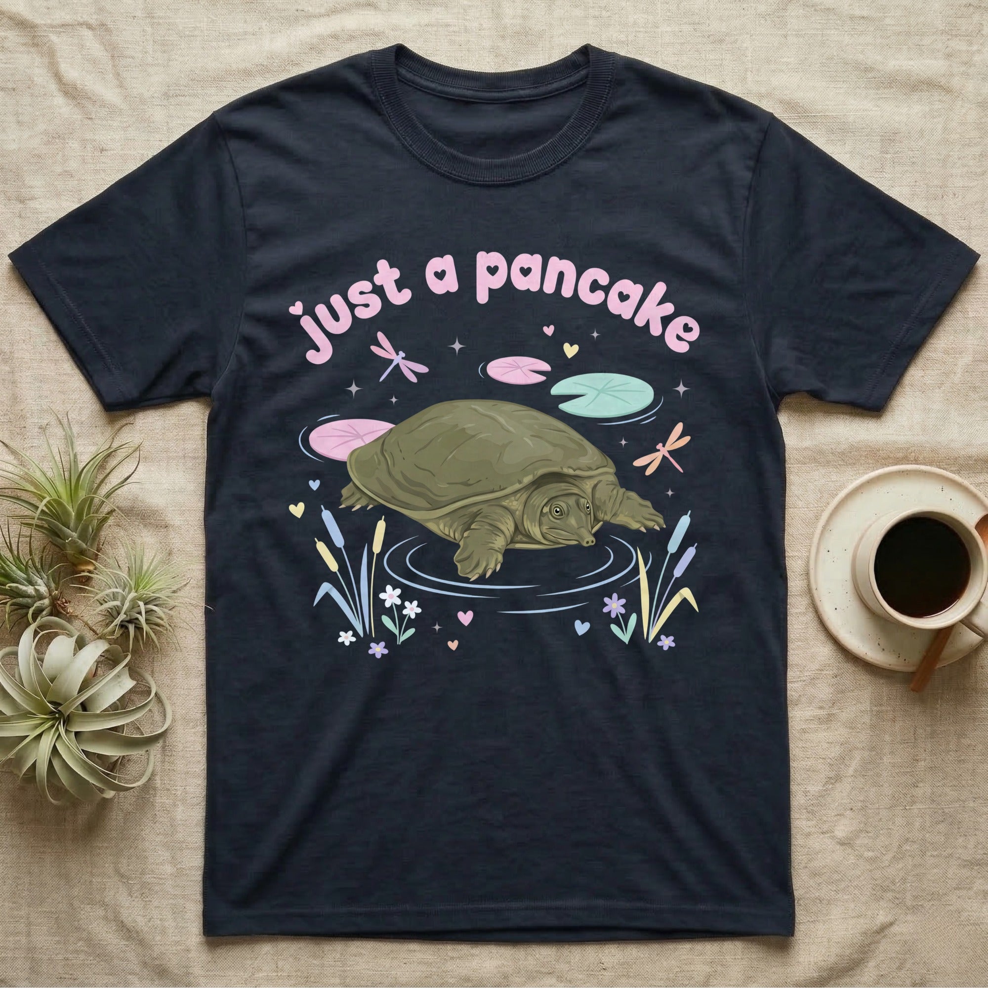 Spiny Softshell Turtle Baby T-Shirt in Navy — Pastel spiny softshell turtle with flat shell and snorkel nose among lily pads, puffy pink wordmark "just a pancake" above.