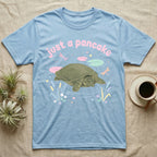 Spiny Softshell Turtle Baby T-Shirt in Light Blue — Pastel spiny softshell turtle with flat shell and snorkel nose among lily pads, puffy pink wordmark "just a pancake" above.