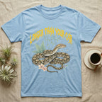 Reticulated Python Feral T-Shirt in Light Blue — Reticulated python in net-patterned coils under jagged molten-gold metal text LONGER THAN YOUR CAR with pastel ferns
