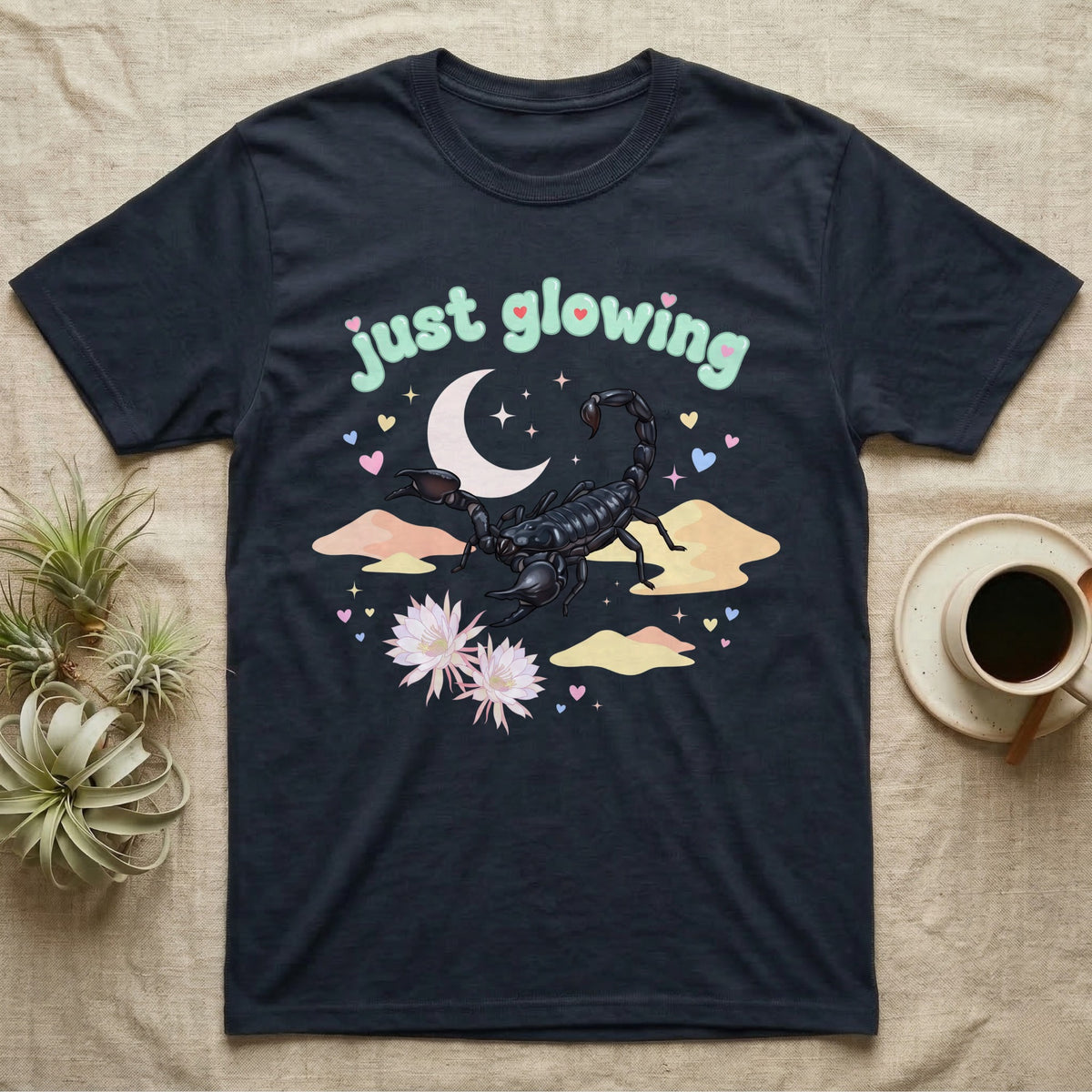 Emperor Scorpion Baby T-Shirt in Navy — Black emperor scorpion, pincers raised, under a pastel moon and stars with puffy mint bubble text "just glowing".