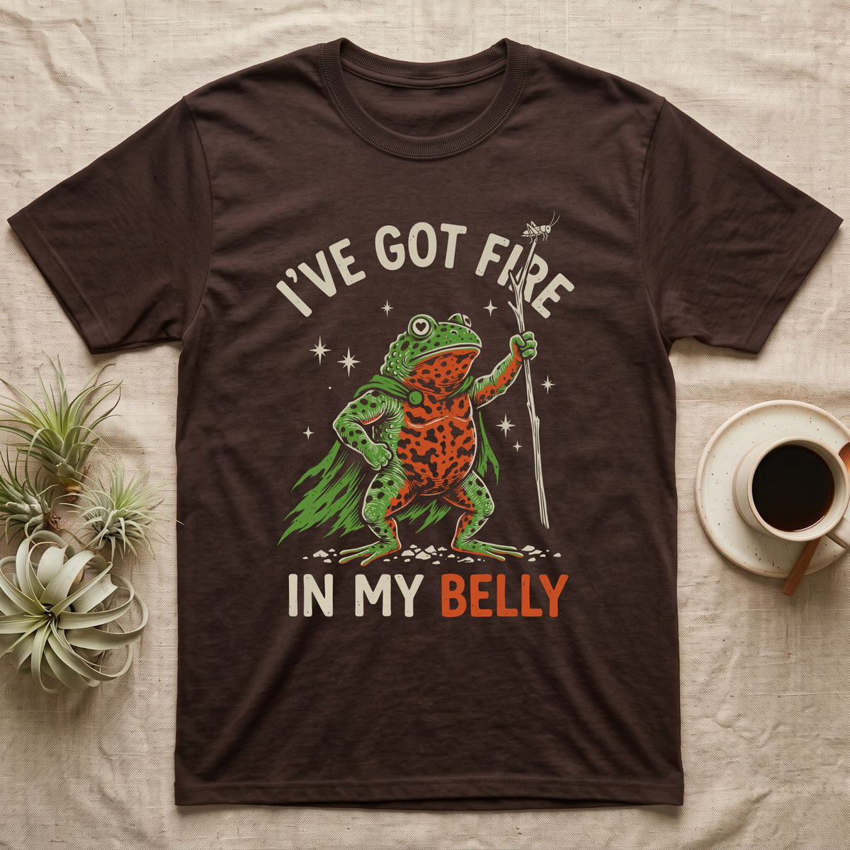 Fire-Bellied Toad Knight T-Shirt in Dark Chocolate — Fire-bellied toad knight with green cape, orange belly and a cricket on a twig spear, lettered I'VE GOT FIRE IN MY BELLY