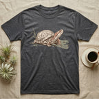 Box Turtle Shell T-Shirt in Dark Heather — Naturalist-plate illustration of a box turtle with its shell shown as living body, above a serif welfare creed caption.