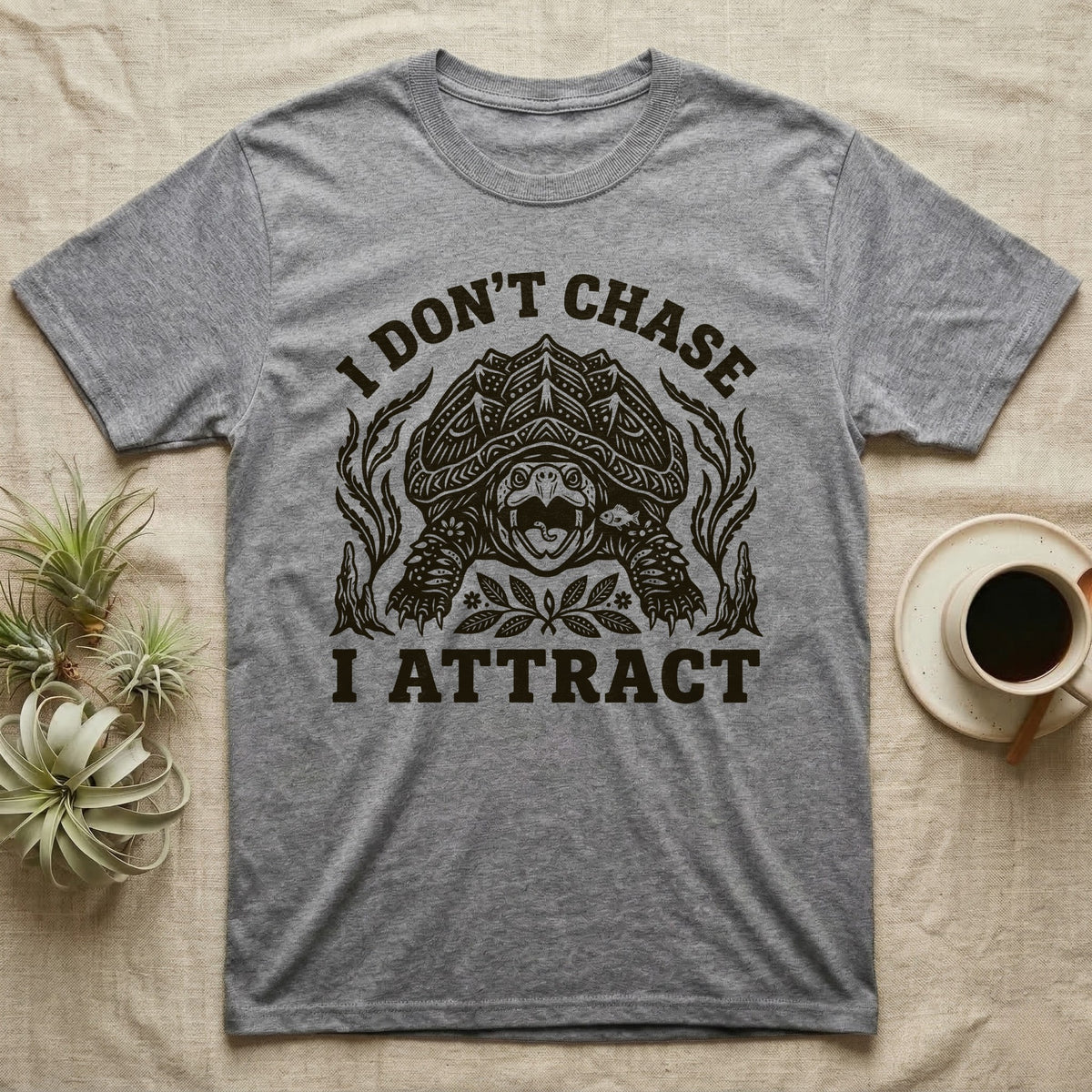 Alligator Snapper Lure T-Shirt in Sport Grey — Folk-print alligator snapping turtle, jaws open, tongue lure out, a fish swimming in, text I Don't Chase I Attract