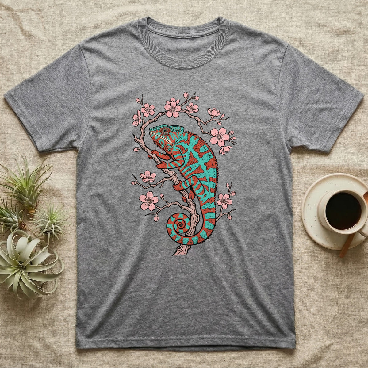Grey t-shirt with a coral and teal chameleon on a cherry blossom branch.