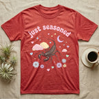 Giant Vinegaroon Baby T-Shirt in Heather Red — Pastel giant vinegaroon with pincers and whip tail among rocks and a crescent moon, puffy pink wordmark "just seasoned" above.