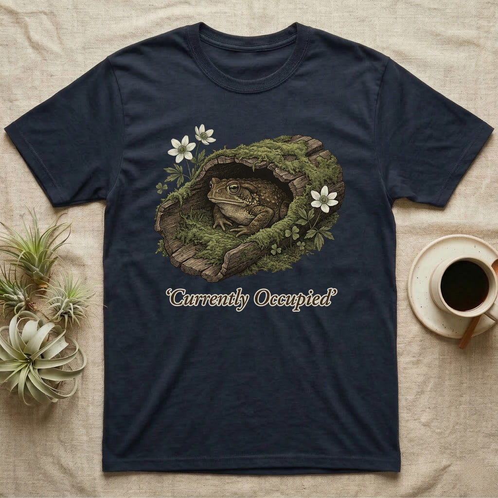 Dark t-shirt with a toad in a mossy log, saying "Currently Occupied".