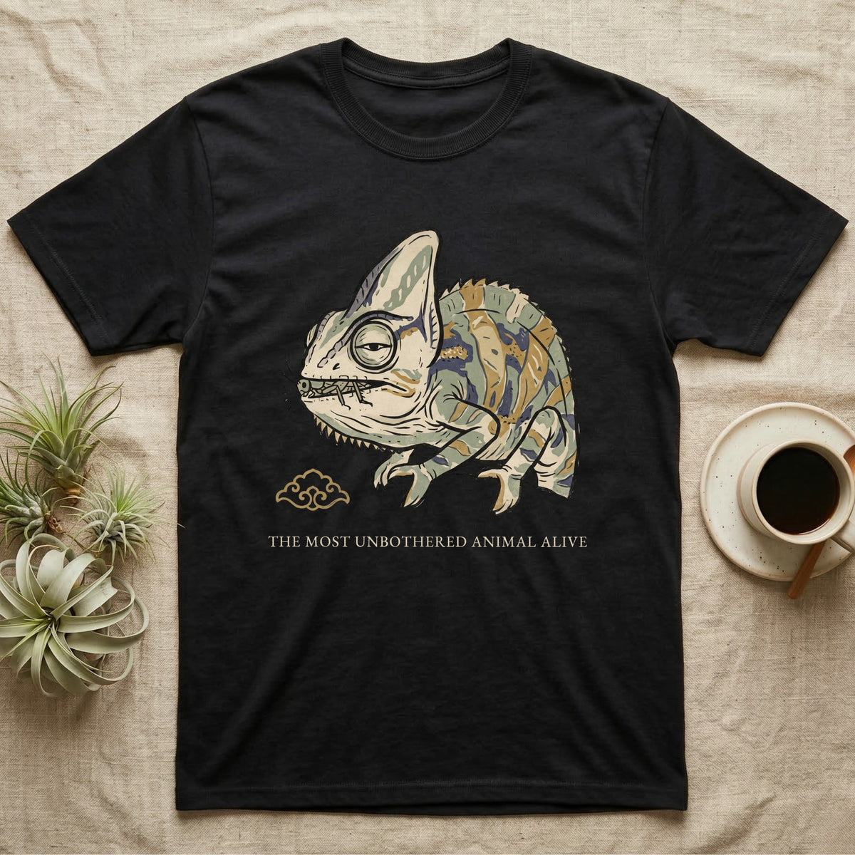 Unbothered Chameleon T-Shirt in Black — Ukiyo-e woodblock illustration of a veiled chameleon mid-chew with a deadpan serif caption beneath the subject.