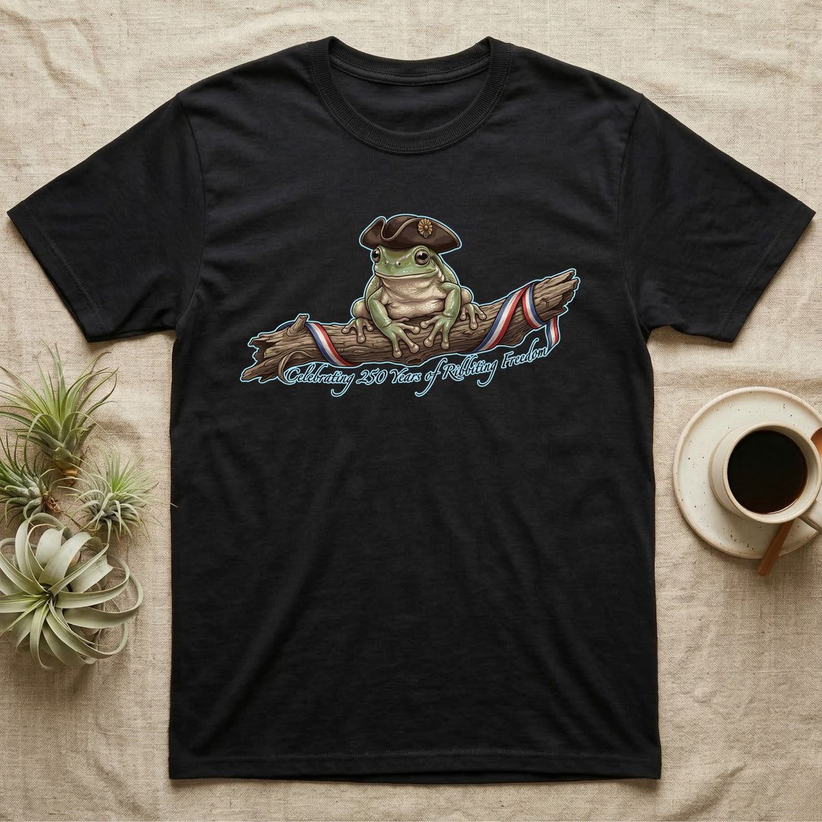 Tree Frog Freedom T-Shirt in Black — Detailed green tree frog in a tricorn hat on a ribboned branch under script Celebrating 250 Years of Freedom.