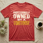 Owned By A Tortoise T-Shirt in Heather Red — Distressed woodtype wordmark reading professionally owned by a tortoise in a bold two-tier lockup, text only.