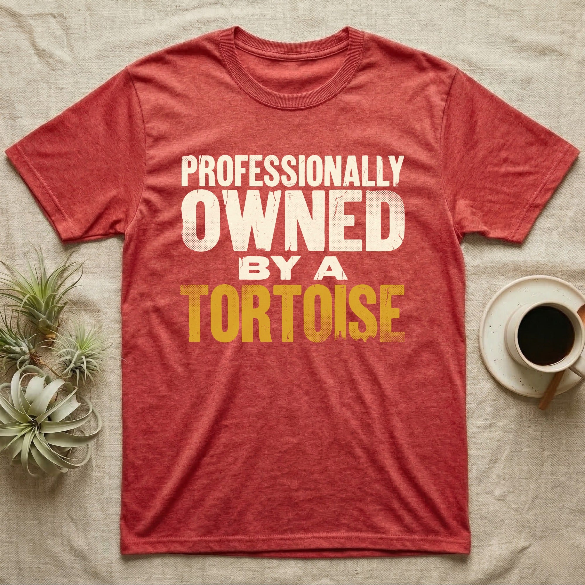 Owned By A Tortoise T-Shirt in Heather Red — Distressed woodtype wordmark reading professionally owned by a tortoise in a bold two-tier lockup, text only.
