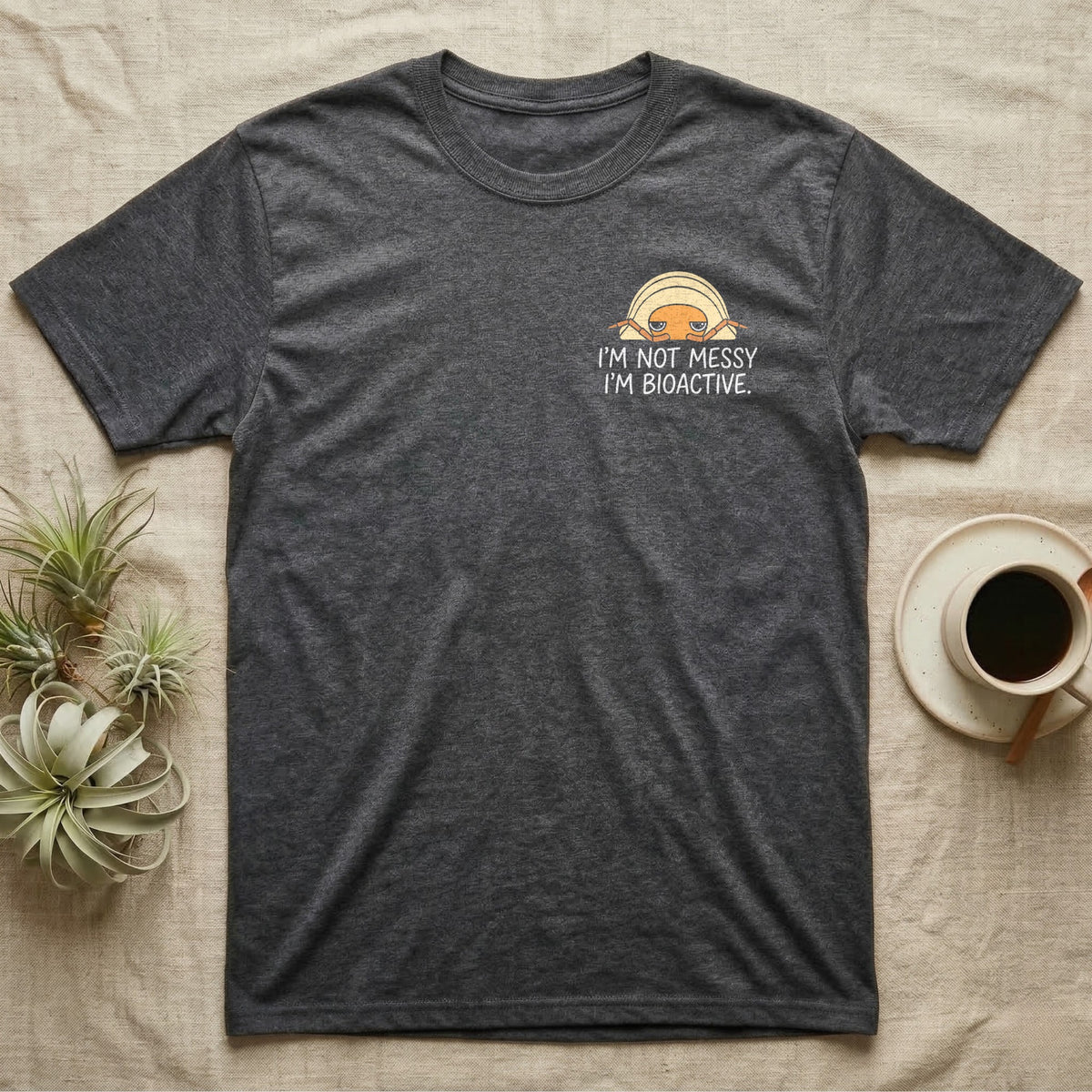 Bioactive Rubber Ducky T-Shirt in Dark Heather — Creamy-yellow rubber ducky isopod with an orange face peeking over white marker capitals reading I'M NOT MESSY I'M BIOACTIVE.