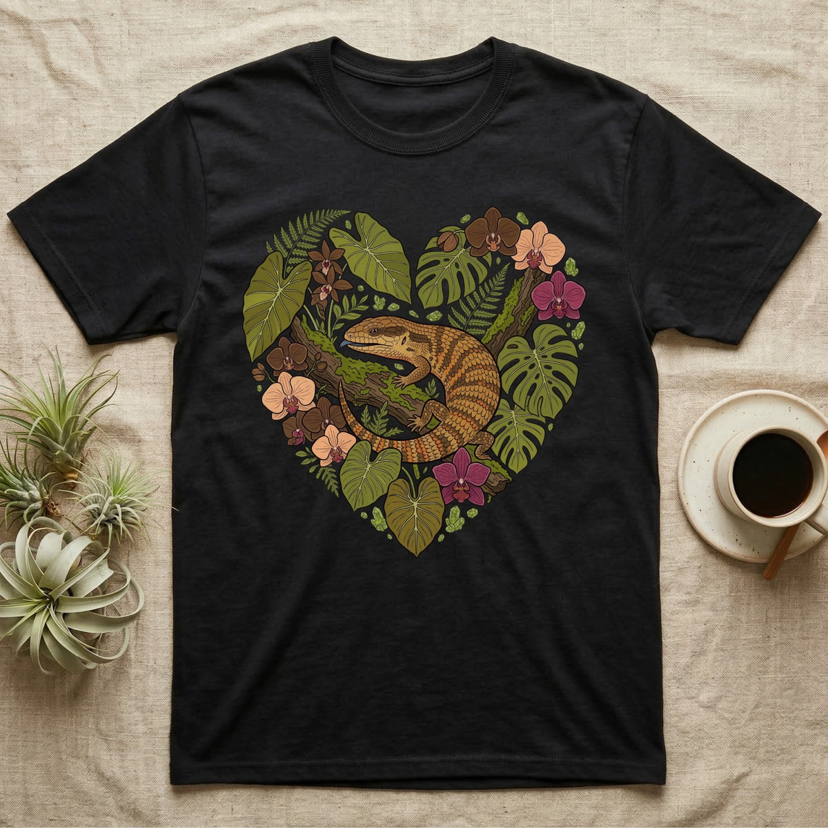 Black t-shirt with heart-shaped nature design featuring a lizard and orchids.