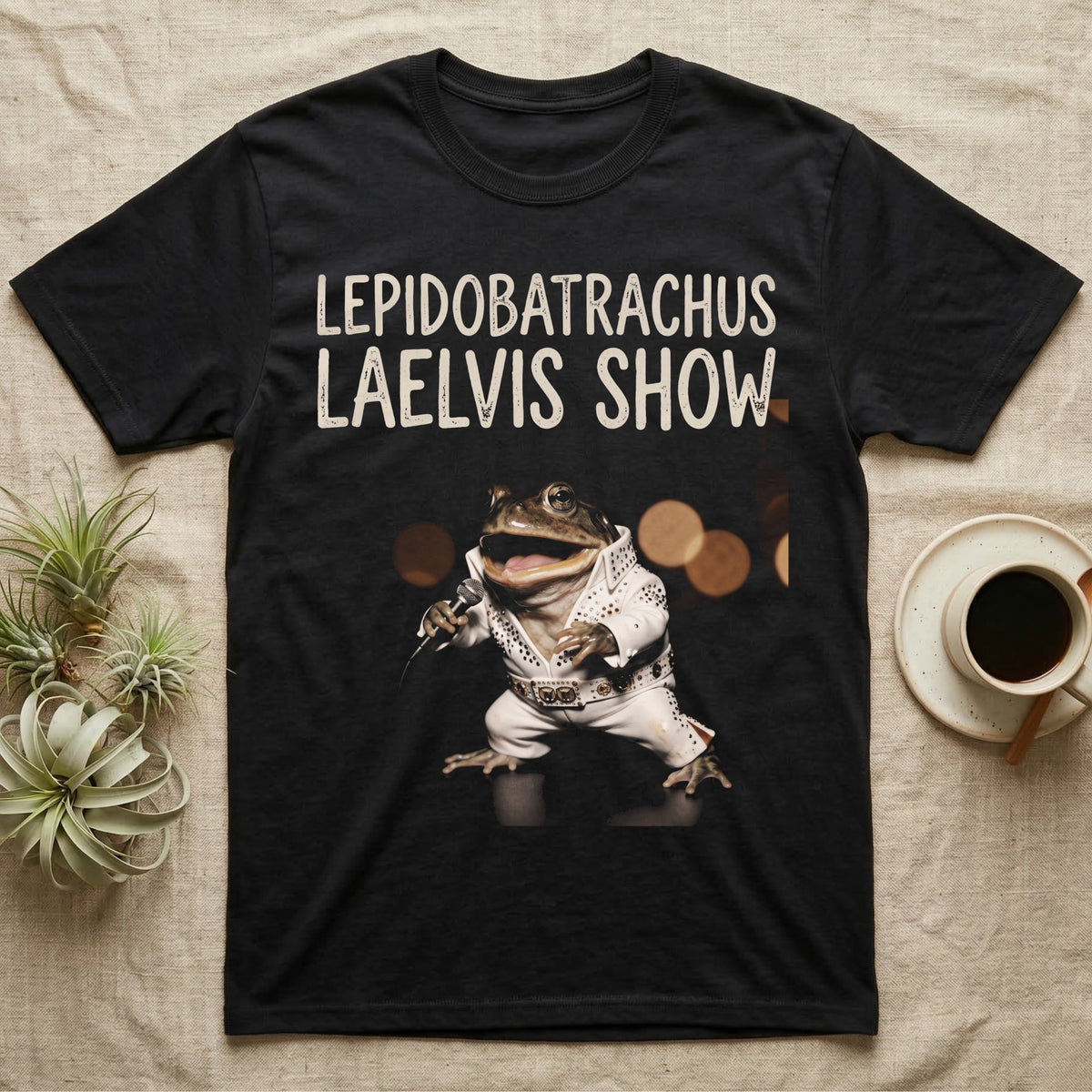Budgett's Frog Rock Star T-Shirt in Black — Budgett's frog in a white rhinestone stage jumpsuit singing into a microphone under a Lepidobatrachus Laelvis Show headline.