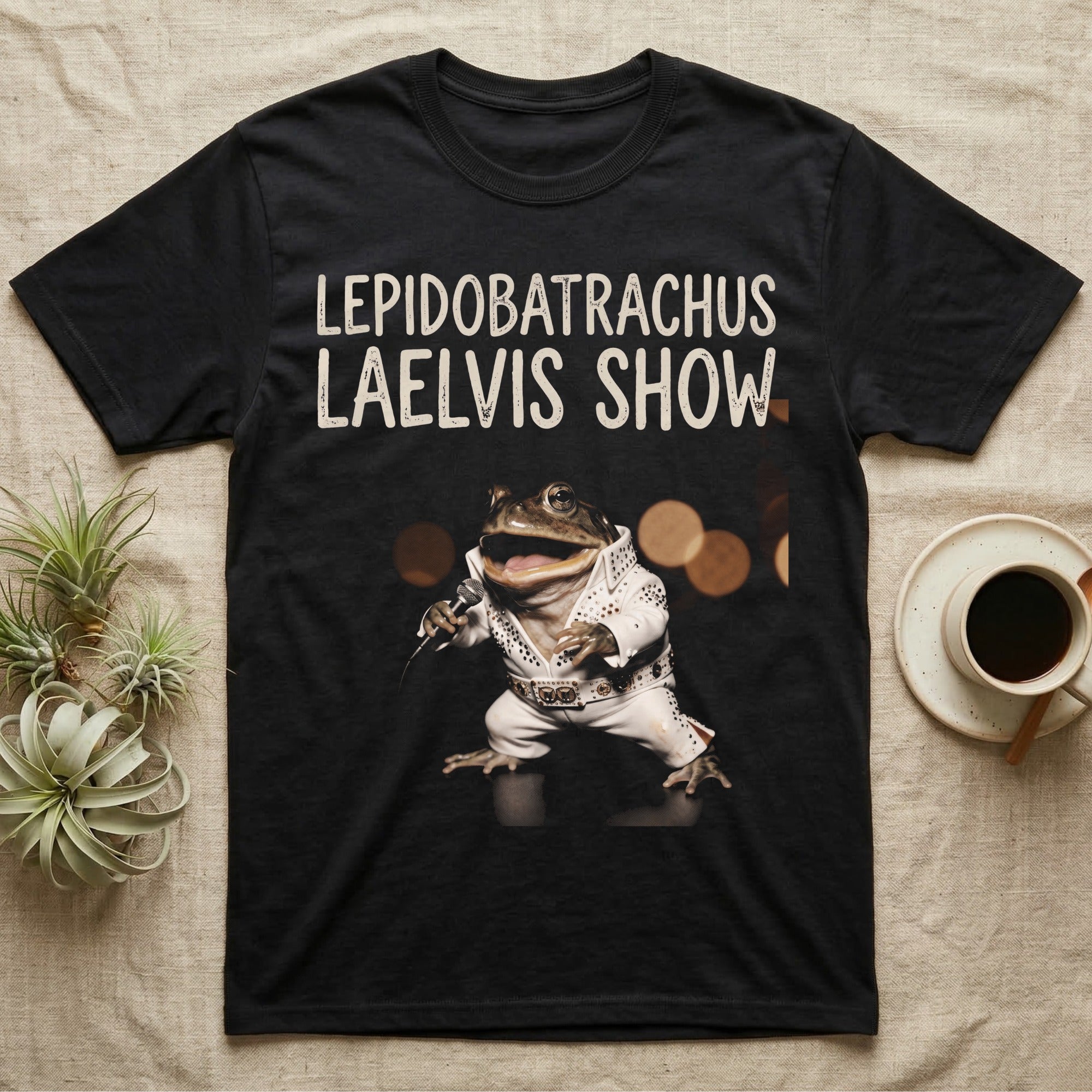 Budgett's Frog Rock Star T-Shirt in Black — Budgett's frog in a white rhinestone stage jumpsuit singing into a microphone under a Lepidobatrachus Laelvis Show headline.