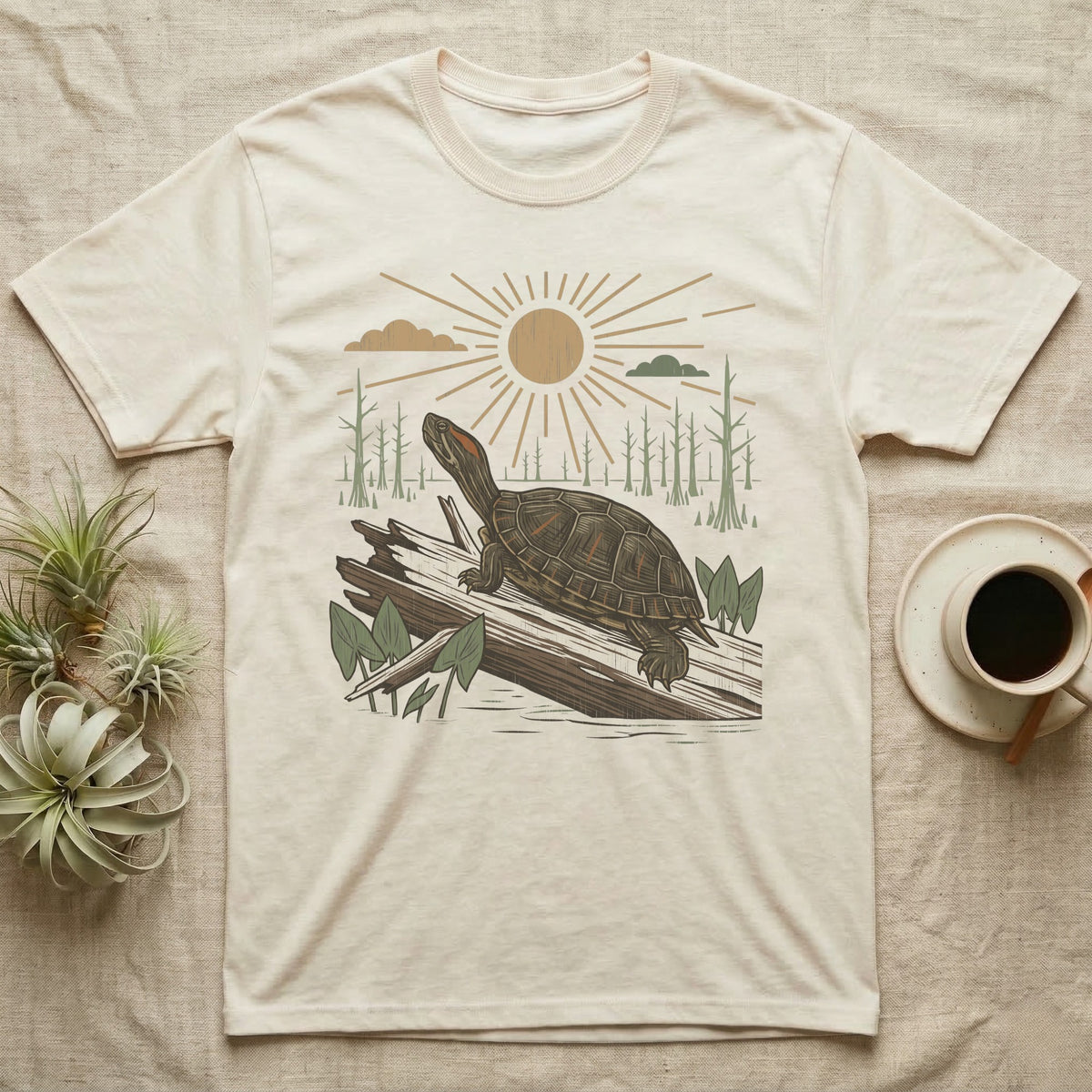Red-Eared Slider Home Range T-Shirt in Natural — Woodcut-style illustration of a red-eared slider basking on a half-sunk log in a cypress swamp under a full sun, no on-shirt text.