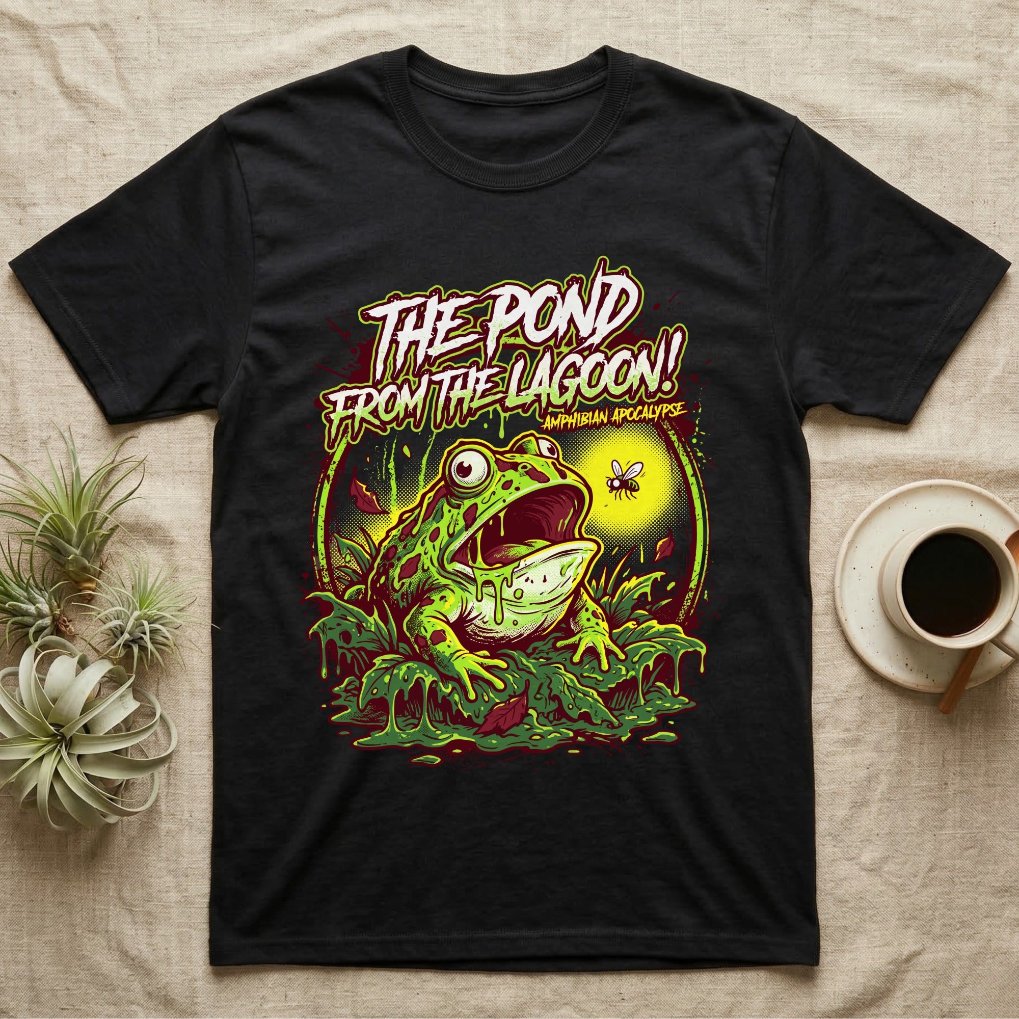 Pacman Frog Lagoon Apocalypse T-Shirt in Black — B-movie horror poster of a Pacman frog bursting from slime at a fly, "The Pond From the Lagoon, Amphibian Apocalypse."