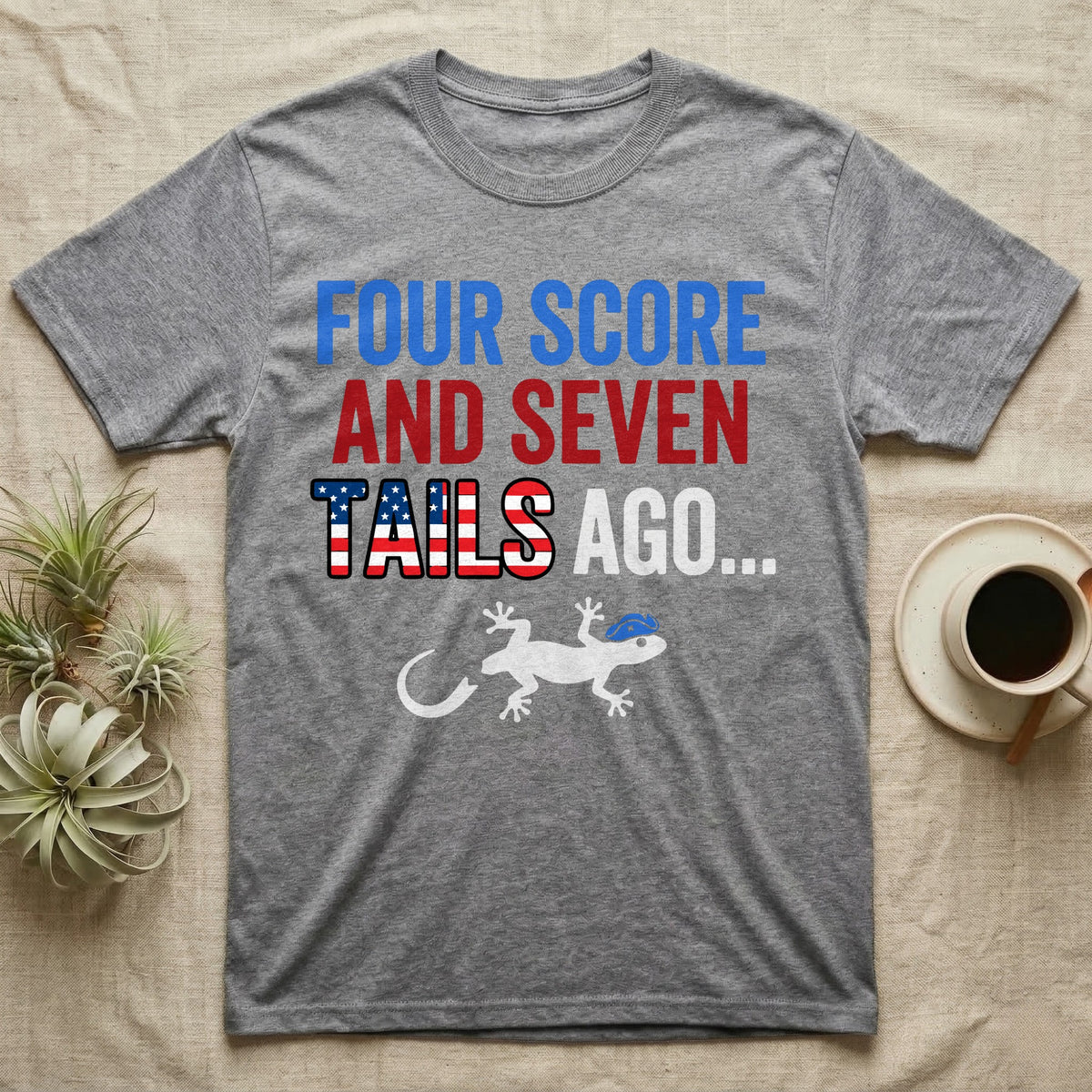 Gecko Four Score T-Shirt in Sport Grey — Block text Four Score and Seven Tails Ago with a flag-filled word above a white gecko silhouette shedding its tail.