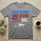 Gecko Four Score T-Shirt in Sport Grey — Block text Four Score and Seven Tails Ago with a flag-filled word above a white gecko silhouette shedding its tail.