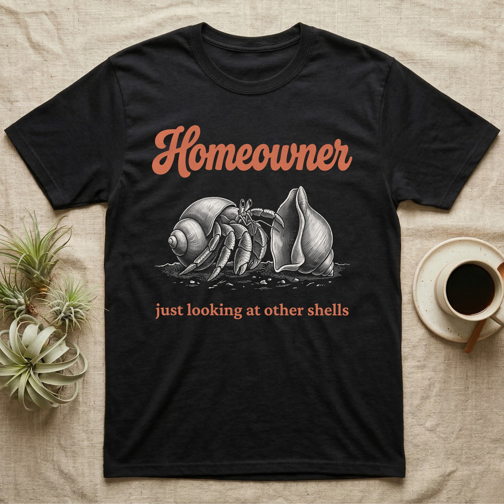 Hermit Crab Homeowner T-Shirt in Black — White-line engraving of a land hermit crab eyeing a bigger empty shell, under orange script Homeowner and a serif line