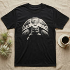Hermann's Tortoise Tough T-Shirt in Black — Black-and-white photo of a Hermann's tortoise staring ahead, a dandelion stem hanging from its beak like a cigarette