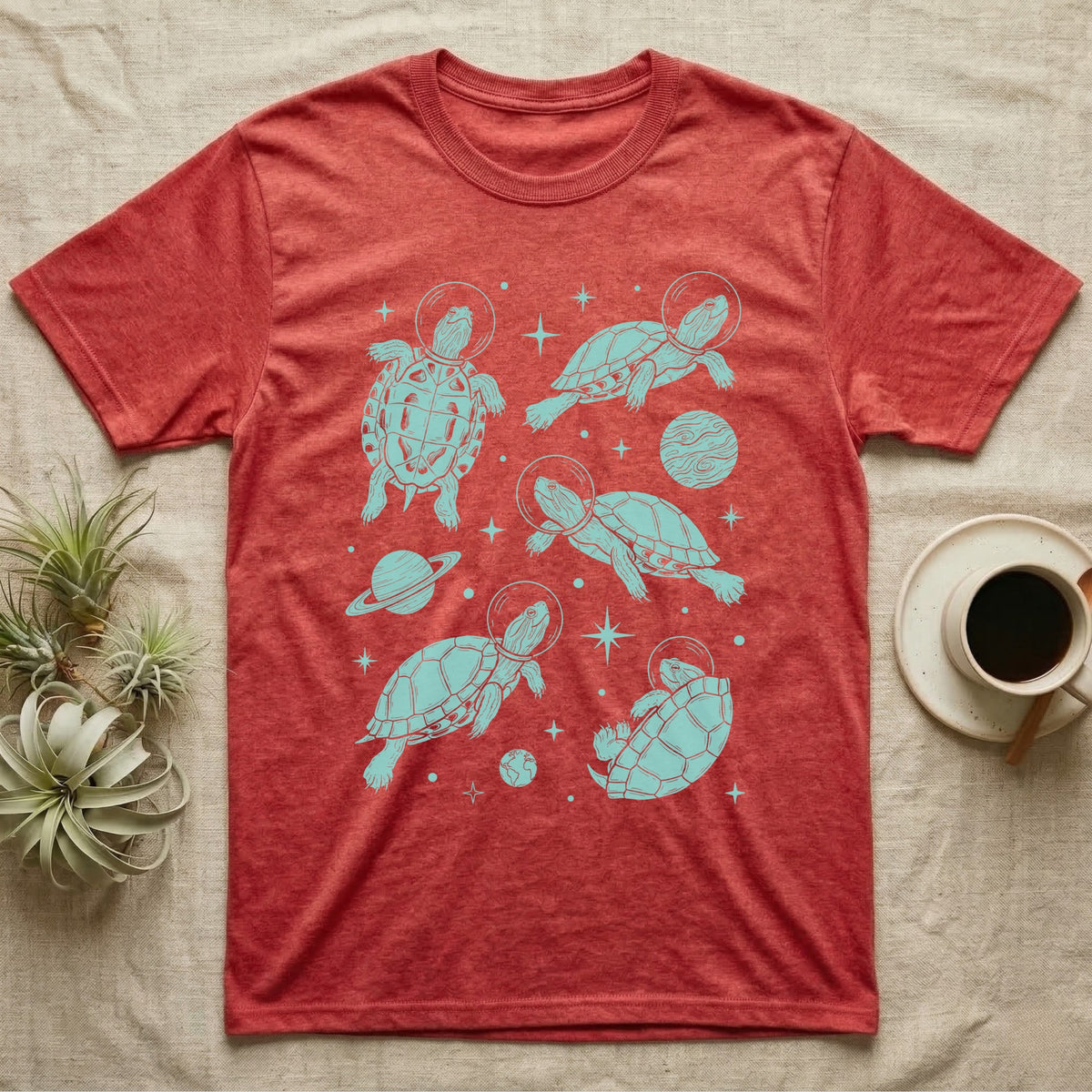 Red Eared Slider Cosmic T-Shirt in Heather Red — Vintage screen-print illustration of red-eared slider turtles in astronaut helmets floating in space, cosmic teal monochromatic on dark background.
