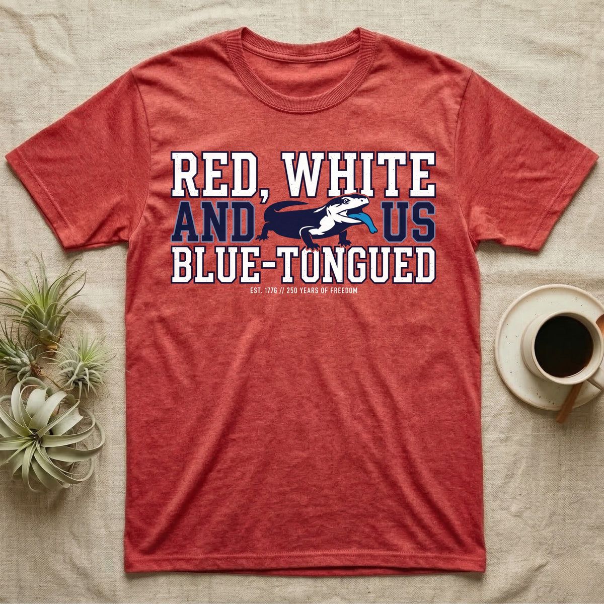 Blue-Tongued Skink 1776 T-Shirt in Heather Red — Navy and white blue-tongued skink with tongue out between collegiate text reading Red, White and US Blue-Tongued.