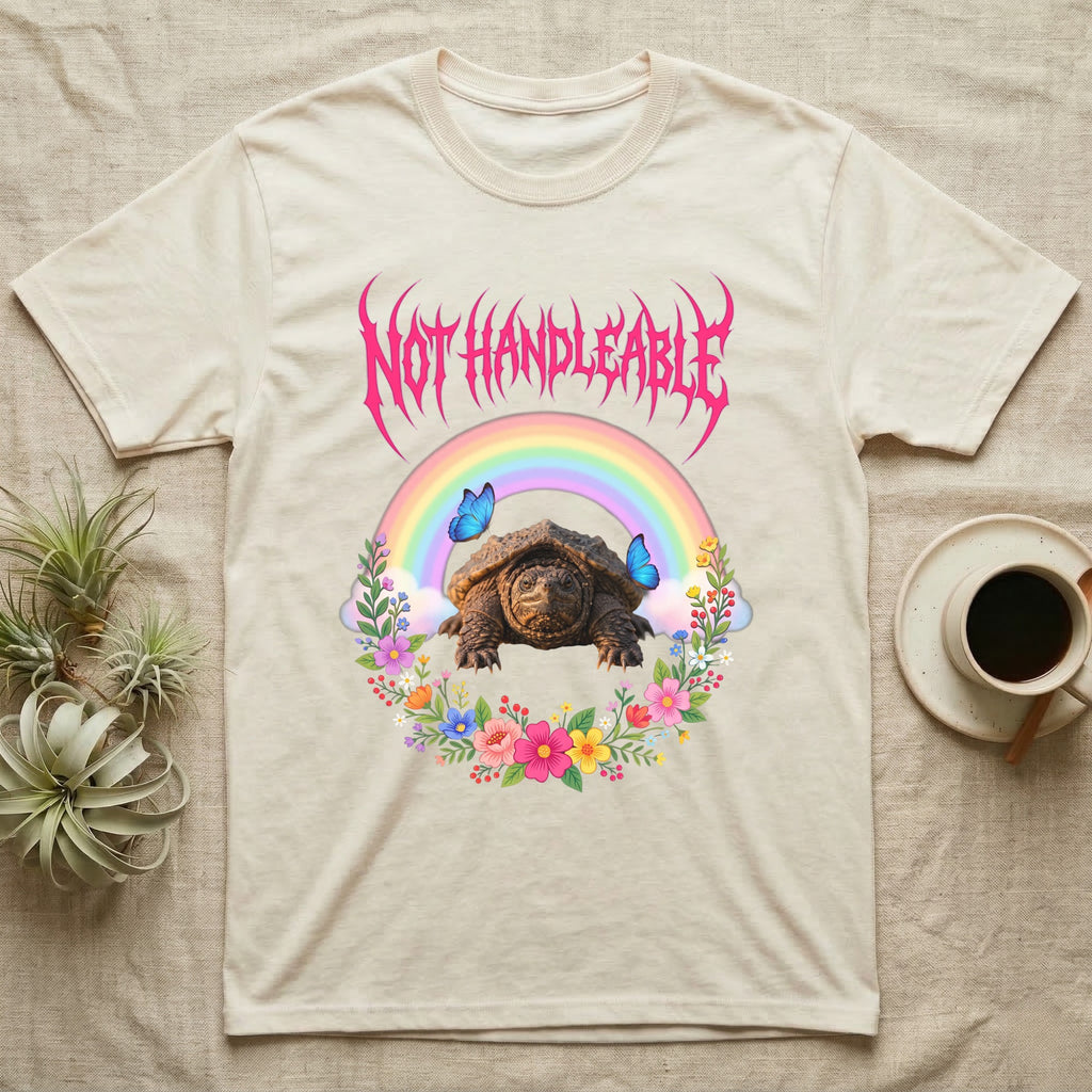 Snapping Turtle Hatchling T-Shirt in Natural — Cute baby snapping turtle in a pastel rainbow and flower wreath under a hot pink metal logo reading NOT HANDLEABLE