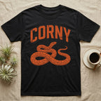 Corn Snake Corny T-Shirt in Black — Worn orange one-ink print of a corn snake lying in loose coils, head raised, under the arched word Corny