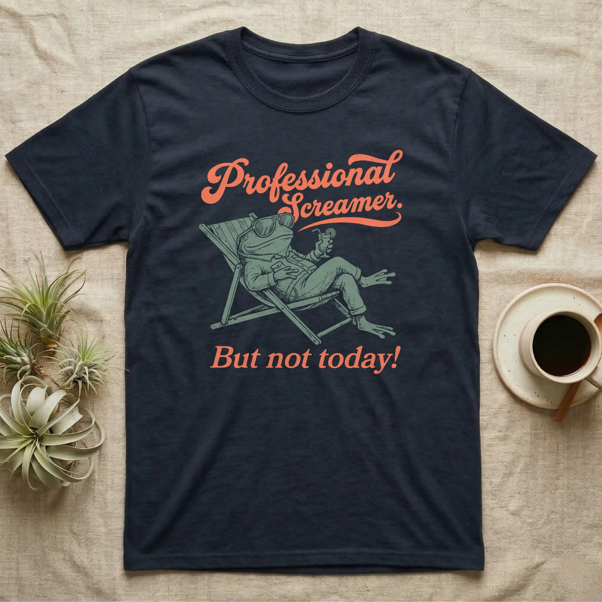Budgett's Frog Day Off T-Shirt in Navy — Illustrated Budgett's frog lounging in a beach chair in a jacket with sunglasses and a cocktail, coral script reading Professional Screamer But Not Today.