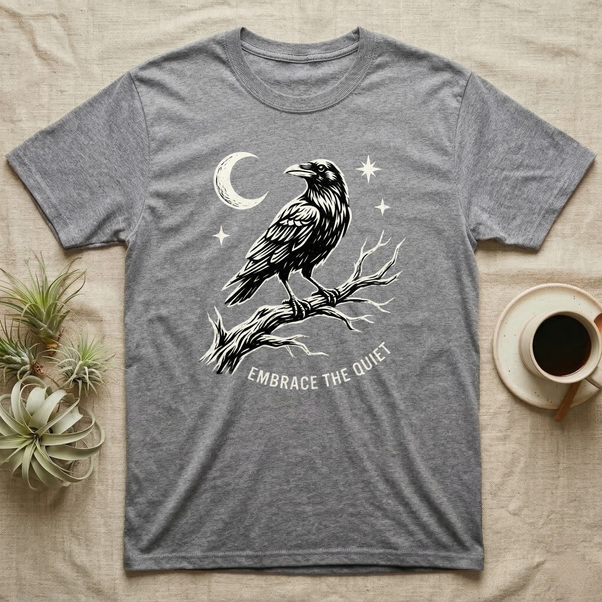Grey t-shirt with a raven on a branch and text "Embrace the Quiet".
