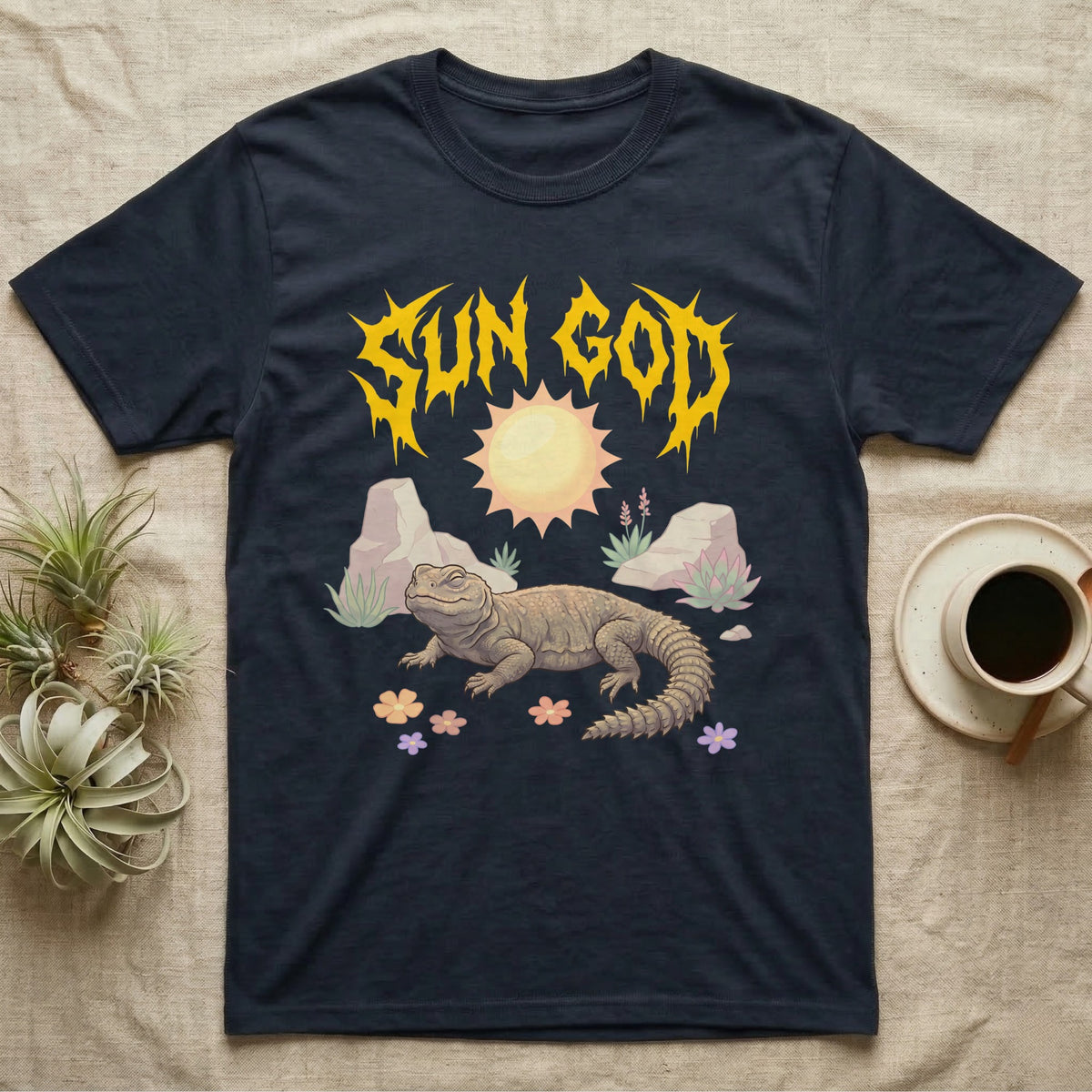 Moroccan Uromastyx Feral T-Shirt in Navy — Moroccan uromastyx basking under a big sun with a jagged solar-gold metal "SUN GOD" wordmark and pastel desert scene.