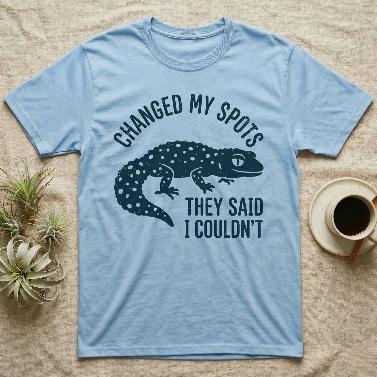 Leopard Gecko Spots T-Shirt in Light Blue — Navy silhouette of a spotted leopard gecko walking under arched words Changed My Spots, beside They Said I Couldn't