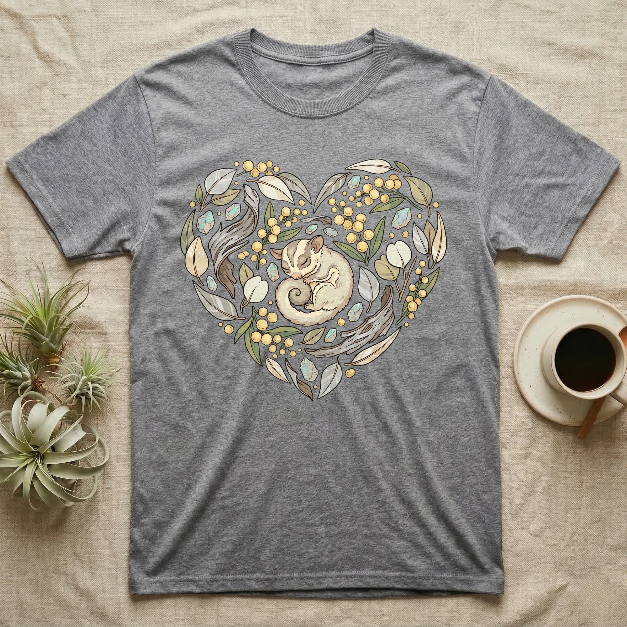 Grey t-shirt with a heart-shaped design of a sugar glider and leaves.