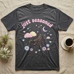 Giant Vinegaroon Baby T-Shirt in Dark Heather — Pastel giant vinegaroon with pincers and whip tail among rocks and a crescent moon, puffy pink wordmark "just seasoned" above.