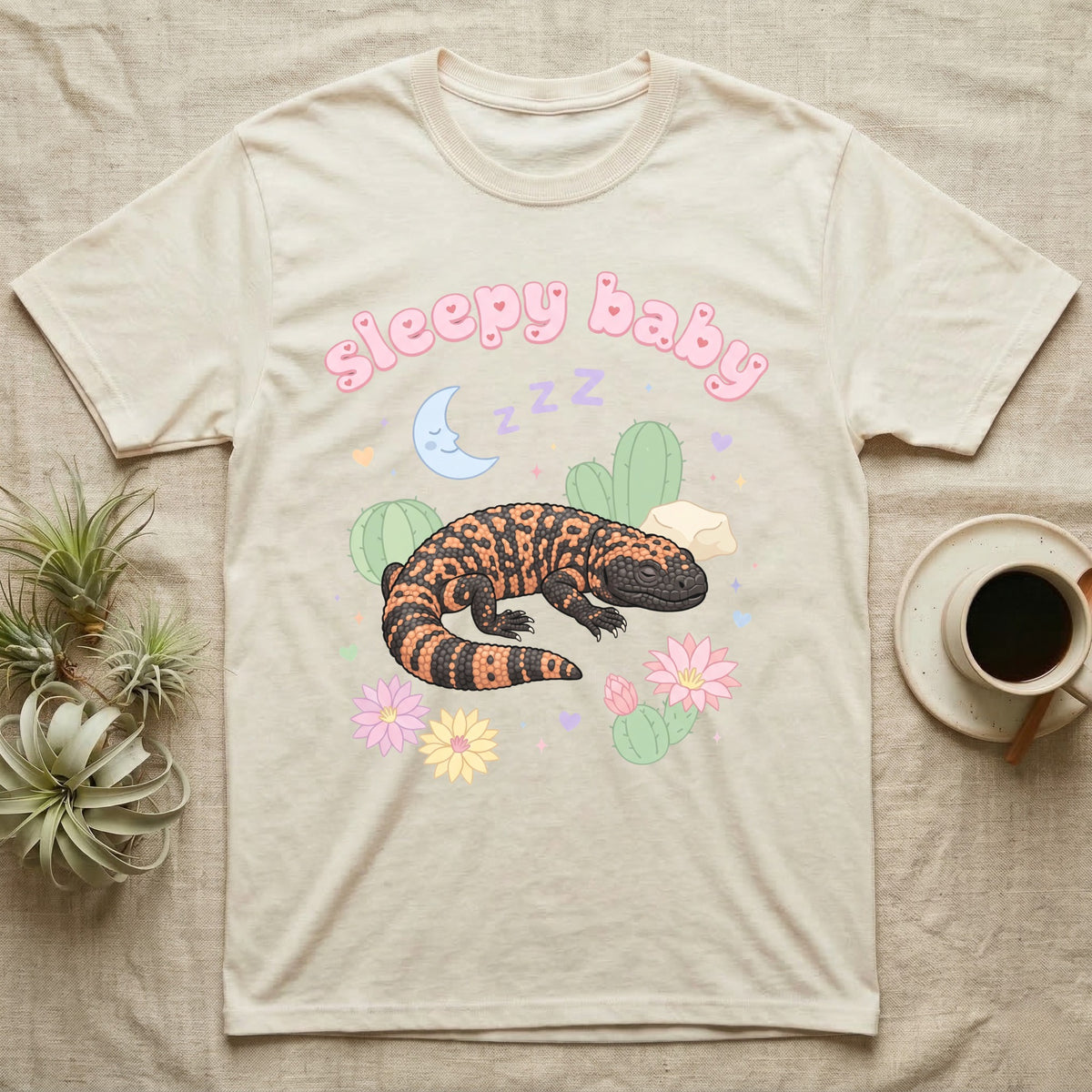Gila Monster Baby T-Shirt in Natural — Pastel Gila monster with sleepy eyes, crescent moon and Z Z Z, puffy salmon bubble wordmark "sleepy baby" above.