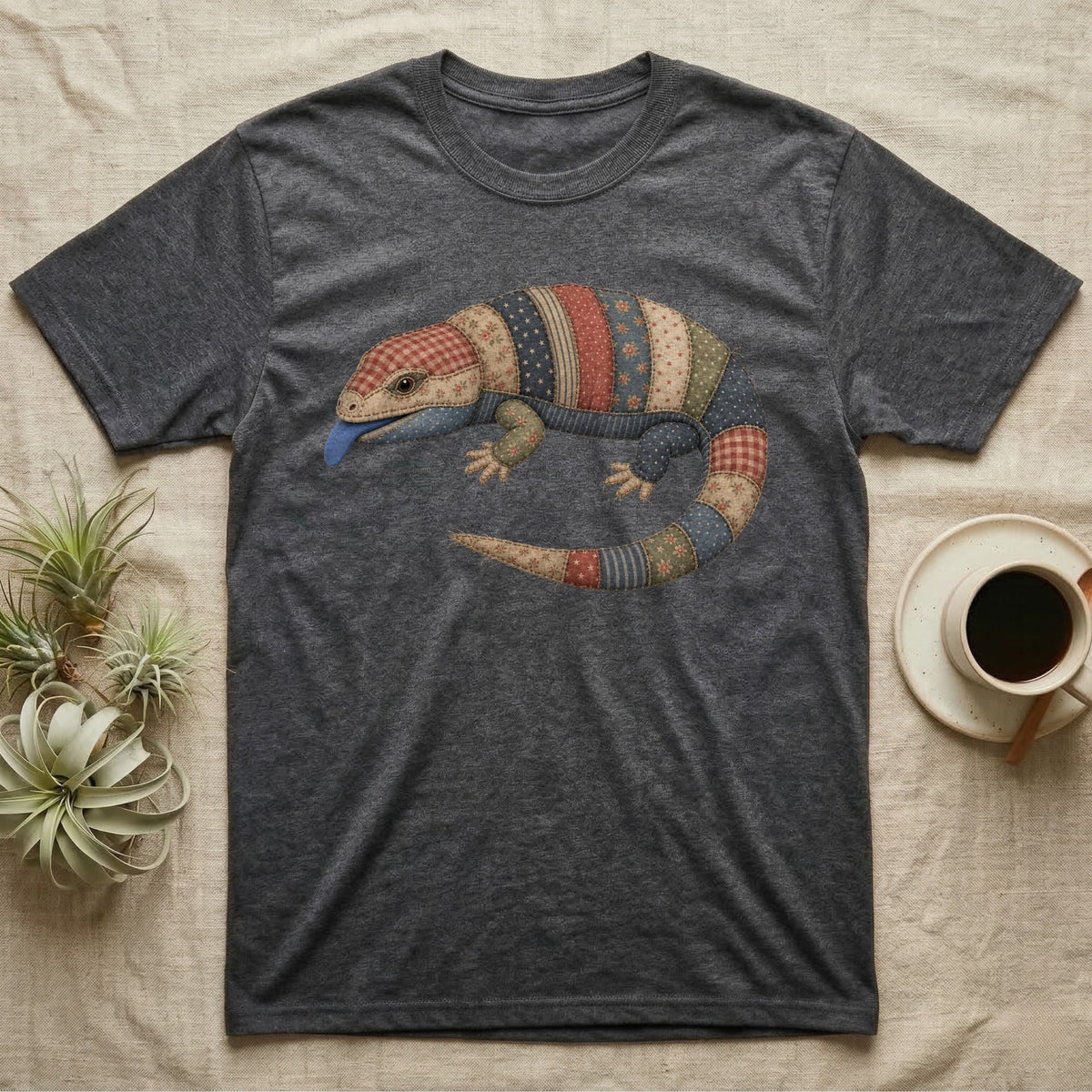 Dark grey t-shirt with a colorful patchwork lizard design and blue tongue.